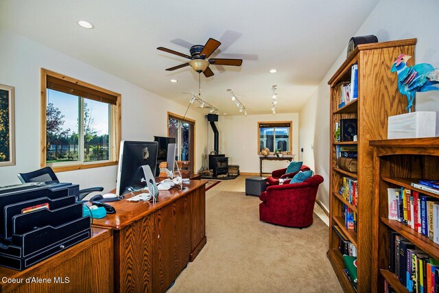 carpeted office with ceiling fan, recessed lighting, and a wood stove