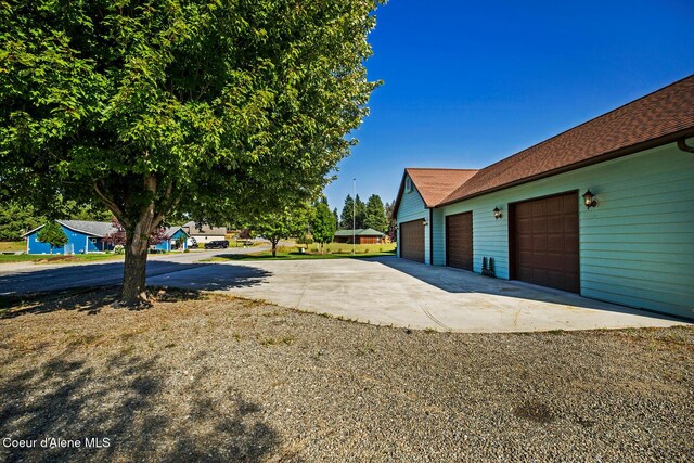 view of yard with an attached garage and concrete driveway
