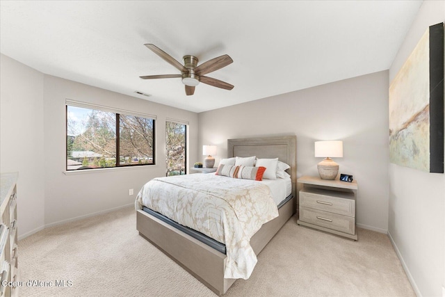 bedroom featuring light colored carpet, a ceiling fan, baseboards, and visible vents