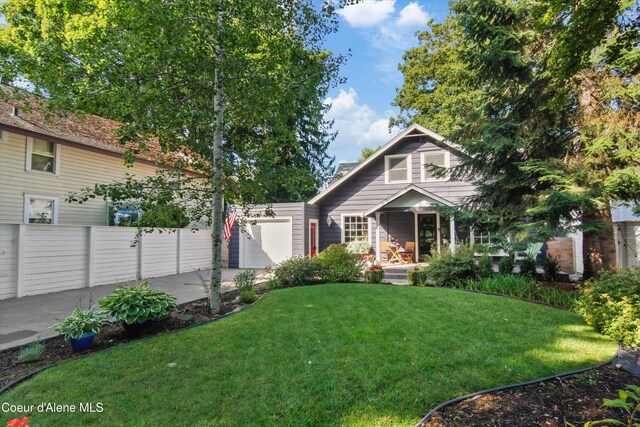 419 N Park Dr, Coeur Dalene, ID 83814 - view of front facade featuring fence, an attached garage, driveway, covered porch, and a front yard