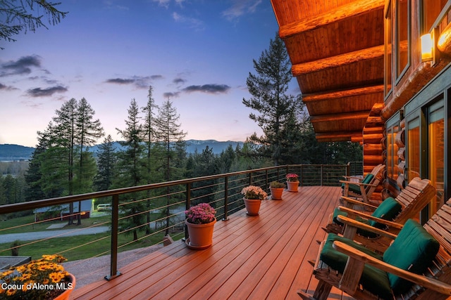 deck at dusk featuring a mountain view