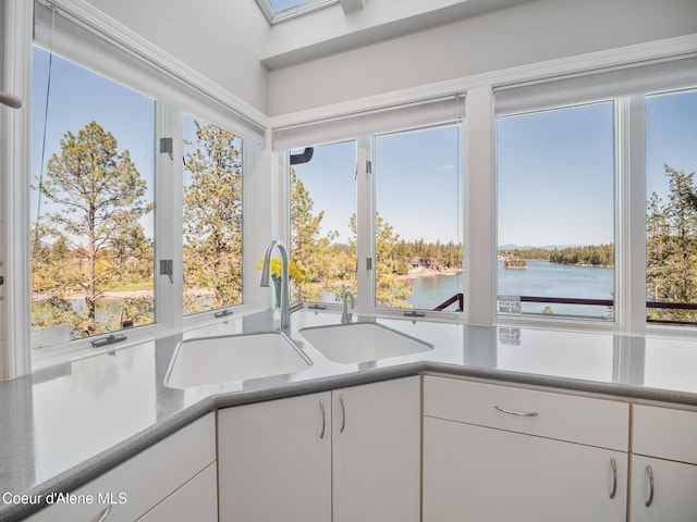 255 S Theresa Terrace Dr, Post Falls, ID 83854 - kitchen featuring a sink, a water view, white cabinets, and light countertops