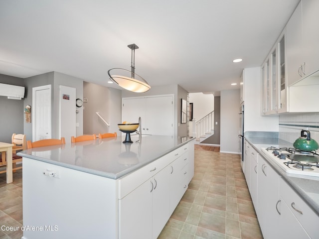 255 S Theresa Terrace Dr, Post Falls, ID 83854 - kitchen featuring a center island, an AC wall unit, white gas cooktop, recessed lighting, and white cabinetry