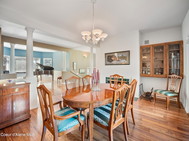 255 S Theresa Terrace Dr, Post Falls, ID 83854 - dining space featuring visible vents, decorative columns, wood finished floors, baseboards, and a notable chandelier