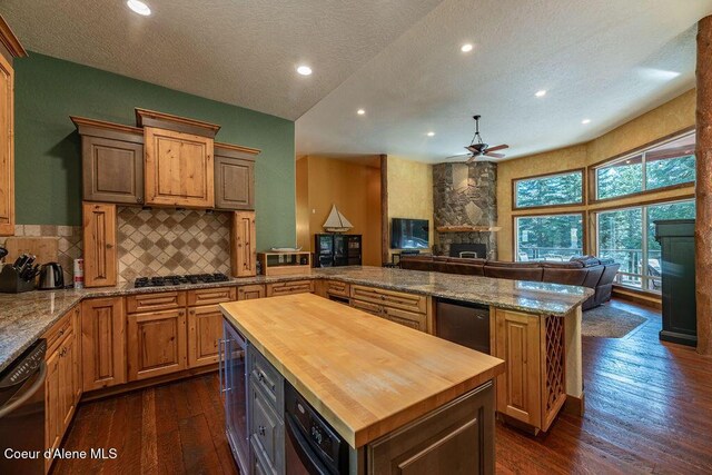 131 Long Dr, Priest Lake, ID 83856 - kitchen featuring a peninsula, wooden counters, a fireplace, a ceiling fan, and open floor plan