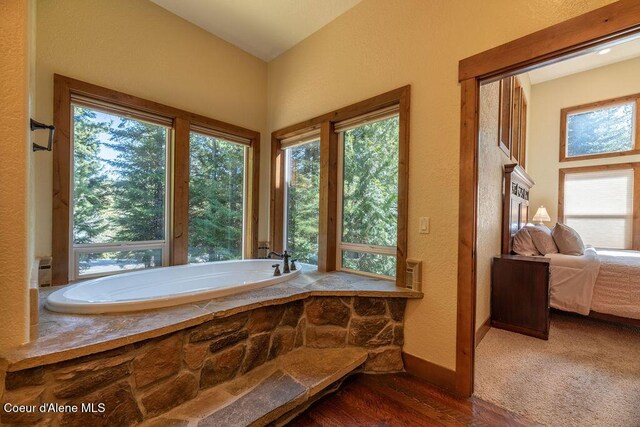 131 Long Dr, Priest Lake, ID 83856 - ensuite bathroom featuring a textured wall, wood finished floors, ensuite bathroom, and a bath