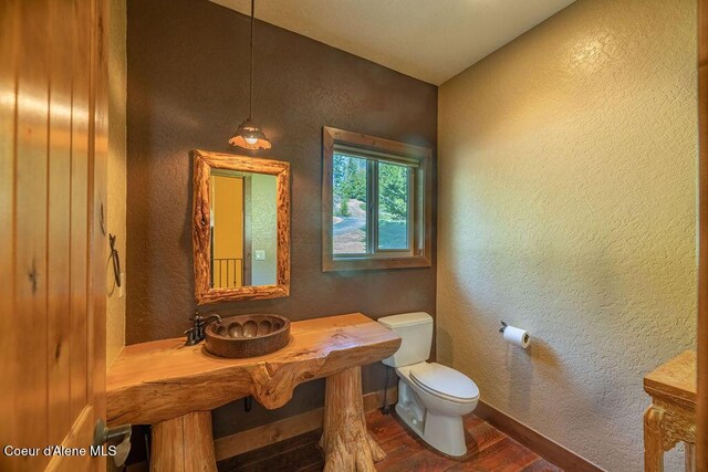 131 Long Dr, Priest Lake, ID 83856 - half bathroom with toilet, a textured wall, wood finished floors, and baseboards