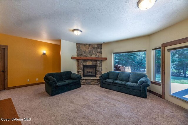 131 Long Dr, Priest Lake, ID 83856 - living room with a wealth of natural light, a textured ceiling, a stone fireplace, and carpet floors