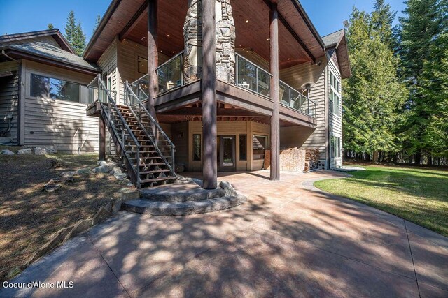 131 Long Dr, Priest Lake, ID 83856 - back of house featuring a patio, stairs, and a lawn