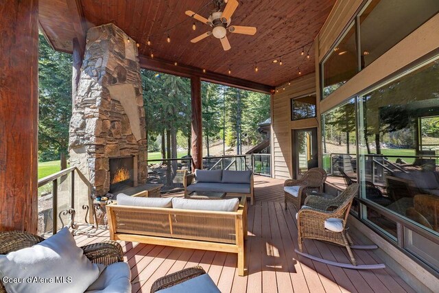 131 Long Dr, Priest Lake, ID 83856 - sunroom with ceiling fan and an outdoor living space with a fireplace