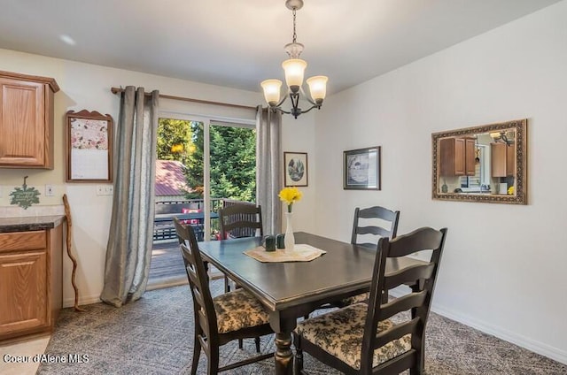 dining area featuring baseboards, a chandelier, and carpet floors