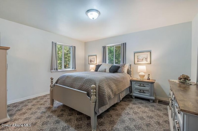 bedroom featuring baseboards, multiple windows, and dark colored carpet