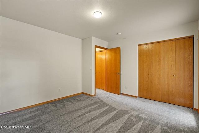 unfurnished bedroom with carpet floors, baseboards, and a closet
