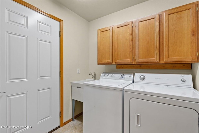 laundry area with cabinet space, washer and dryer, and baseboards