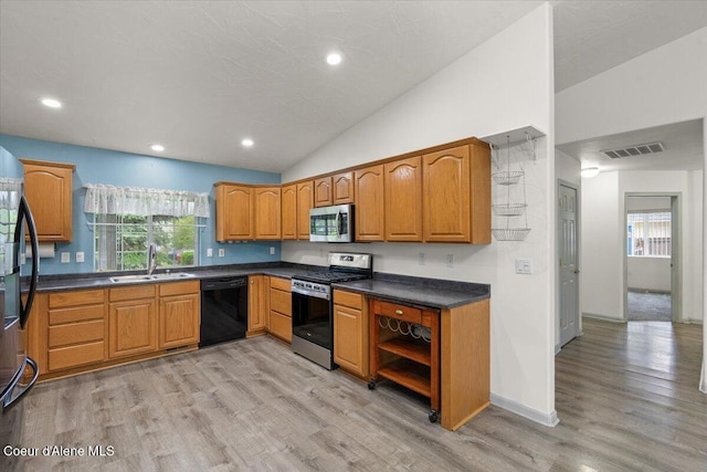 32350 N 7th Ave, Spirit Lake, ID 83869 - kitchen with black appliances, a sink, light wood finished floors, vaulted ceiling, and brown cabinets