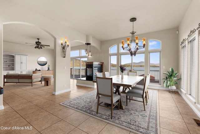 1100 S Division Ave, Sandpoint, ID 83864 - dining area with baseboards, arched walkways, ceiling fan with notable chandelier, and light tile patterned floors