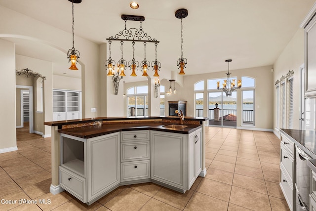 1100 S Division Ave, Sandpoint, ID 83864 - kitchen featuring dark countertops, light tile patterned floors, a notable chandelier, and a sink