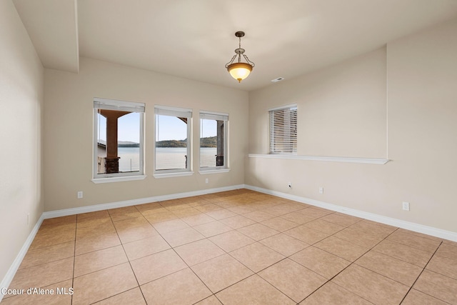 1100 S Division Ave, Sandpoint, ID 83864 - spare room featuring baseboards, a water view, and light tile patterned floors