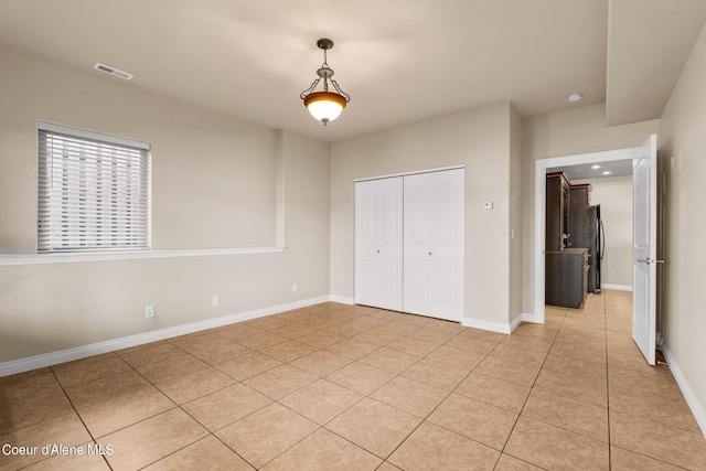 1100 S Division Ave, Sandpoint, ID 83864 - unfurnished bedroom featuring baseboards, visible vents, a closet, and light tile patterned flooring