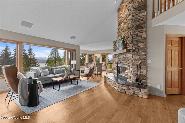 3677 S Capeview Ct, Coeur Dalene, ID 83814 - living area with high vaulted ceiling, plenty of natural light, baseboards, and light wood-type flooring