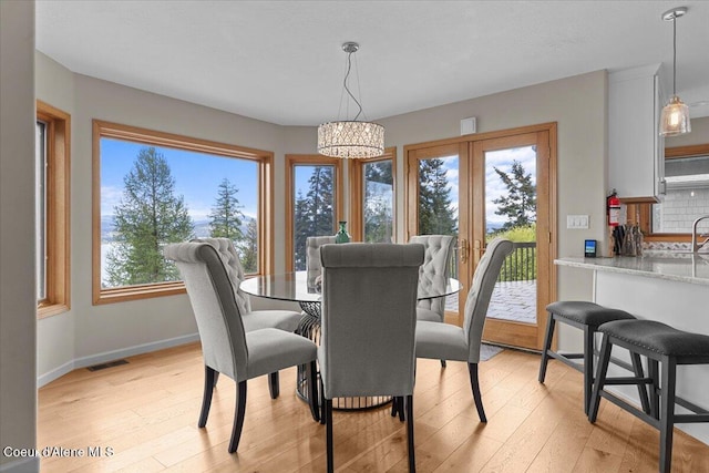 3677 S Capeview Ct, Coeur Dalene, ID 83814 - dining area with visible vents, light wood finished floors, baseboards, and a chandelier