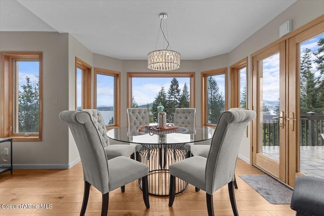 3677 S Capeview Ct, Coeur Dalene, ID 83814 - dining space featuring baseboards, light wood finished floors, and a notable chandelier