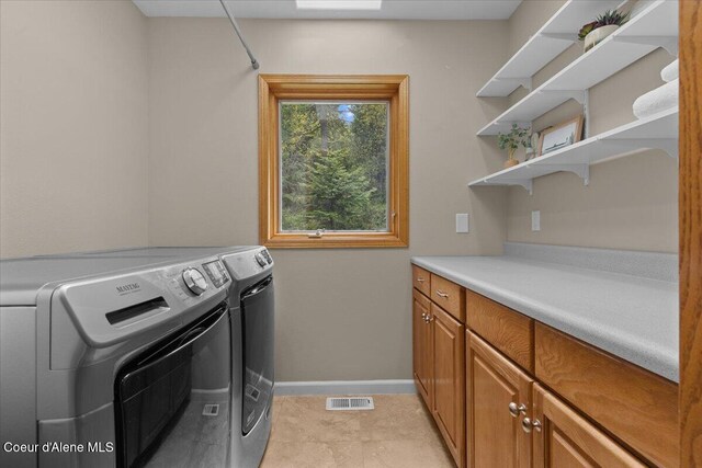 3677 S Capeview Ct, Coeur Dalene, ID 83814 - laundry area featuring independent washer and dryer, baseboards, visible vents, and cabinet space