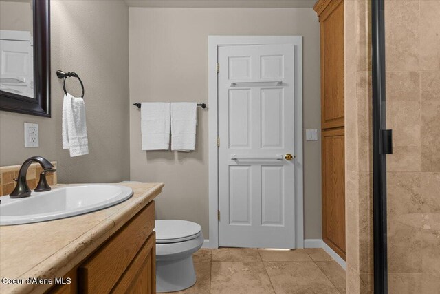 3677 S Capeview Ct, Coeur Dalene, ID 83814 - full bath with a shower with shower door, tile patterned floors, baseboards, vanity, and toilet