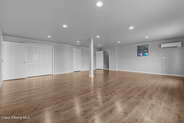 3677 S Capeview Ct, Coeur Dalene, ID 83814 - unfurnished living room featuring recessed lighting, baseboards, a wall mounted AC, and wood finished floors