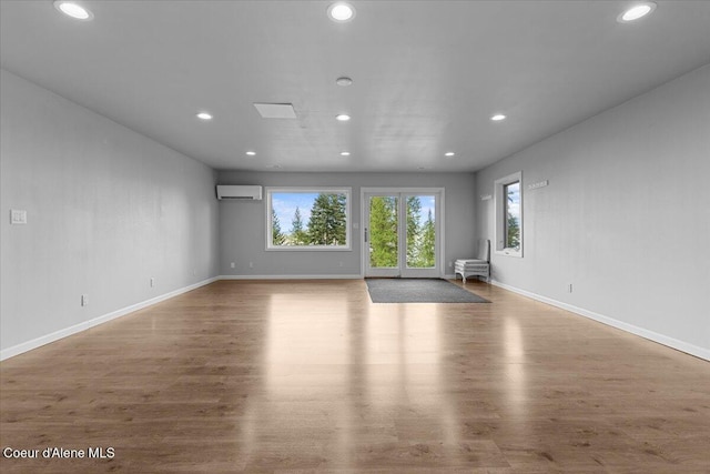 3677 S Capeview Ct, Coeur Dalene, ID 83814 - unfurnished living room with recessed lighting, baseboards, a wall unit AC, and wood finished floors