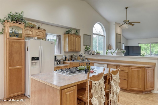 3310 N 17th St, Coeur Dalene, ID 83815 - kitchen featuring vaulted ceiling, white appliances, light countertops, a center island, and light wood-style flooring