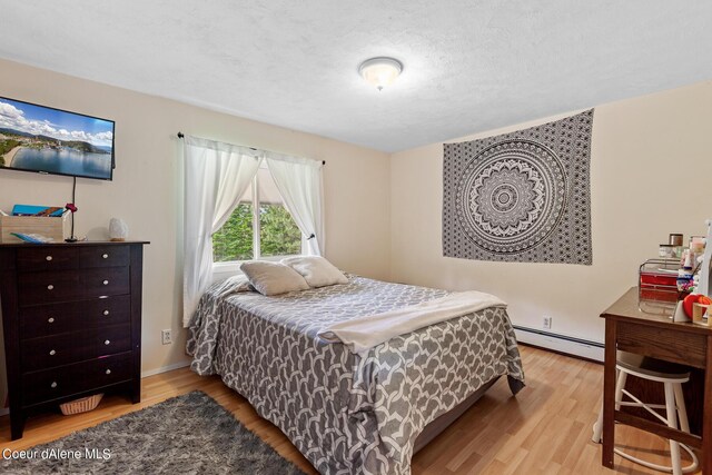 14105 E Marie Creek Rd, Coeur Dalene, ID 83814 - bedroom featuring a baseboard radiator and wood finished floors