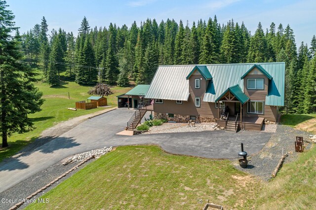 14105 E Marie Creek Rd, Coeur Dalene, ID 83814 - rustic home with metal roof, a front lawn, aphalt driveway, and a view of trees