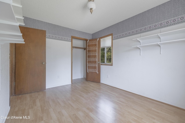 unfurnished bedroom with wood finished floors and a textured ceiling