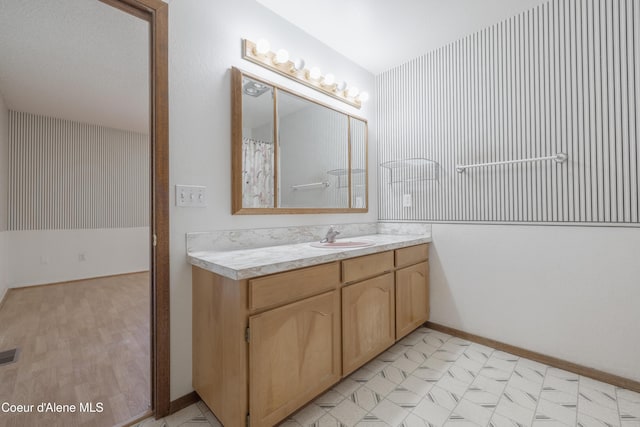 full bathroom with baseboards, visible vents, and vanity