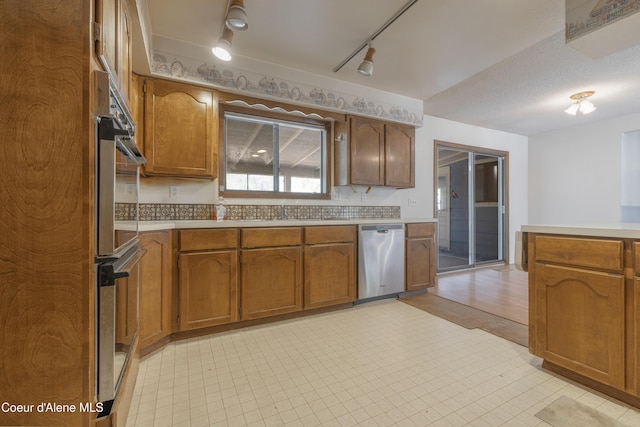 kitchen featuring appliances with stainless steel finishes, light countertops, and brown cabinets