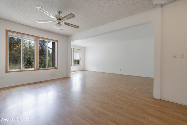 unfurnished room with wood finished floors, ceiling fan, and a textured ceiling