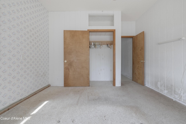 unfurnished bedroom featuring a closet, carpet flooring, and wallpapered walls