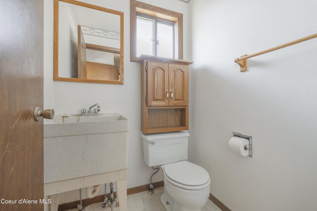 bathroom with baseboards, toilet, and vanity