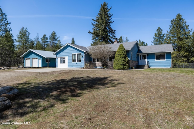 ranch-style house with a chimney, a garage, entry steps, and a front yard