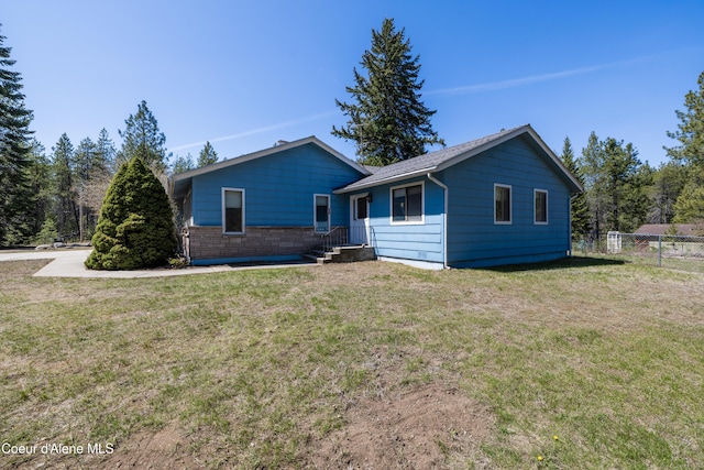 ranch-style home featuring a front yard and fence