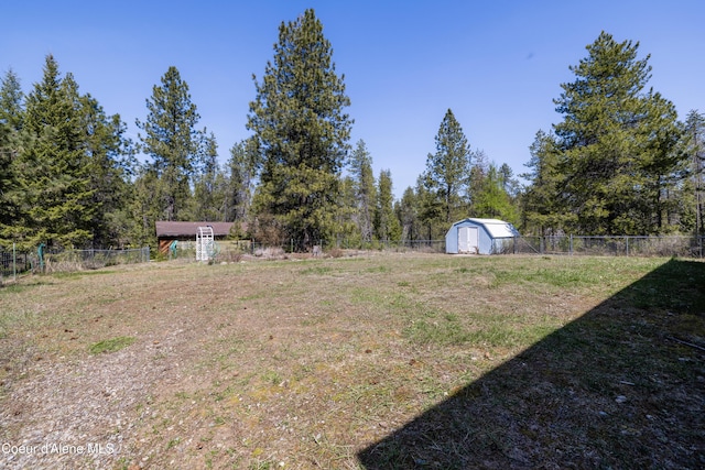 view of yard featuring an outbuilding, a storage unit, and a fenced backyard