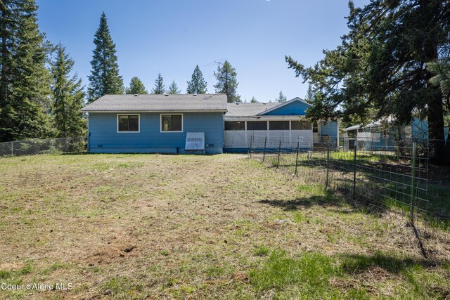 rear view of property featuring a yard and a fenced backyard