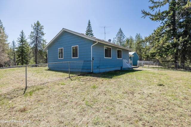 view of side of home featuring a yard and a fenced backyard