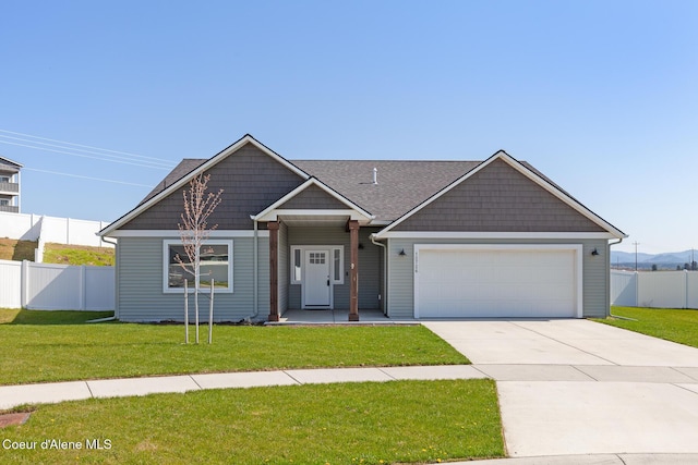 view of front of property with fence, an attached garage, driveway, and a front yard