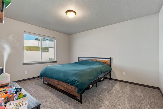 carpeted bedroom with a textured ceiling and baseboards