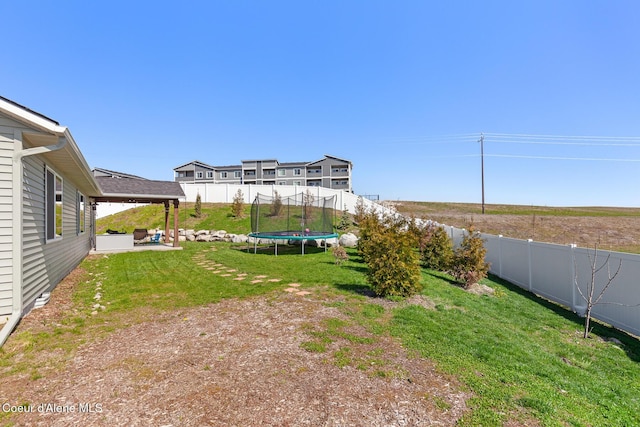 view of yard with a patio, a fenced backyard, and a trampoline