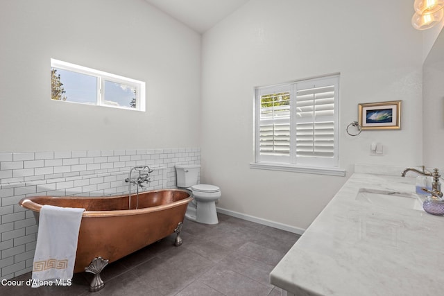 3515 N 7th St, Coeur Dalene, ID 83815 - full bathroom with tile walls, tile patterned floors, double vanity, a freestanding tub, and lofted ceiling