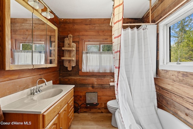 bathroom featuring vanity, toilet, wood walls, a shower with shower curtain, and wood finished floors