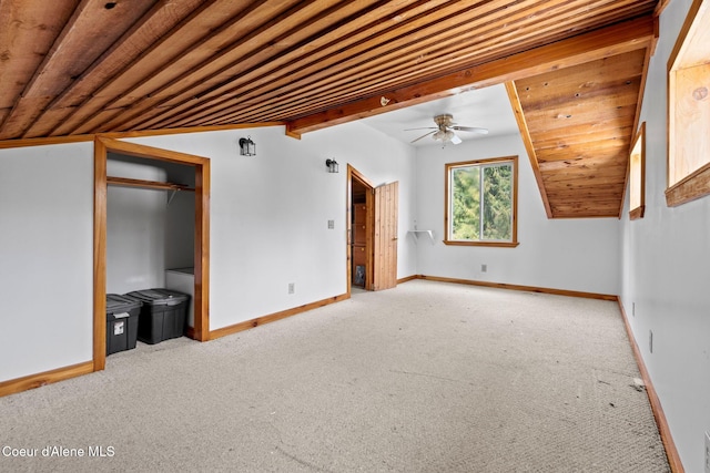 interior space with baseboards, lofted ceiling, wood ceiling, and carpet
